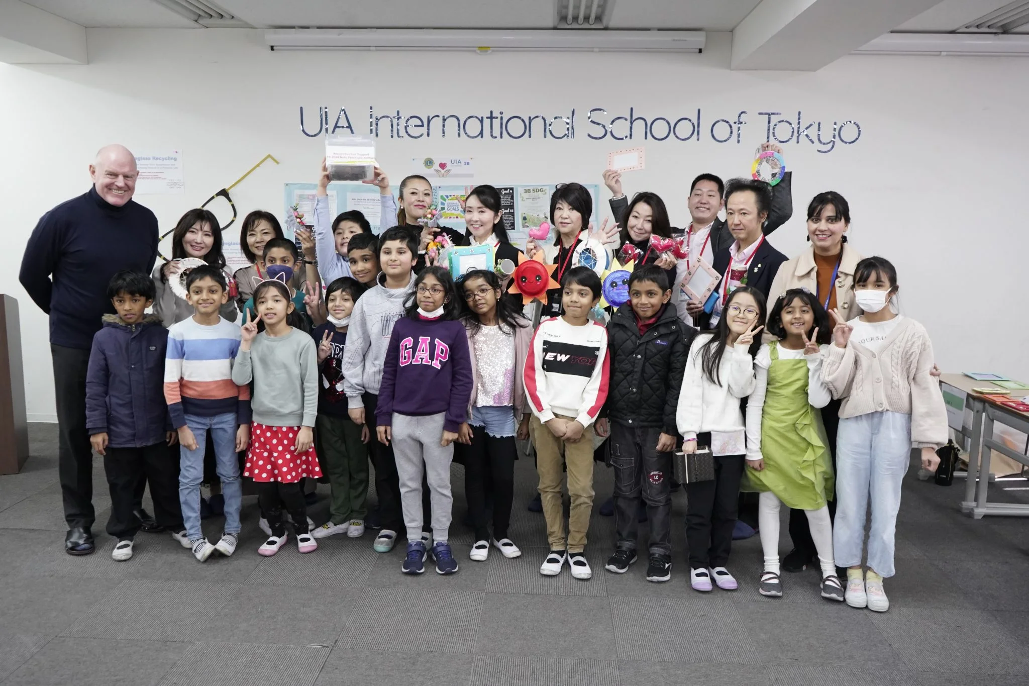Group of students and teachers at UIA International School of Tokyo smiling for a class photo.