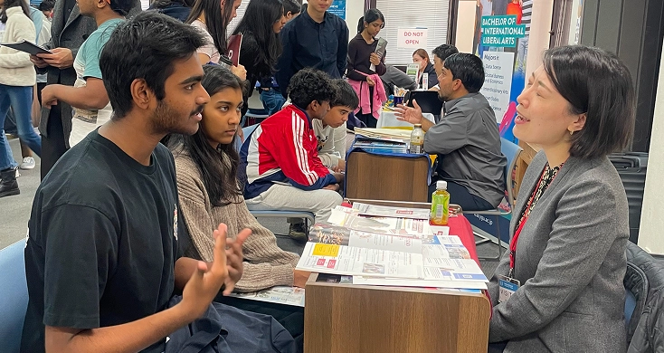 University counselor giving a presentation on student-centered guidance at UIA, Tokyo, to an audience.