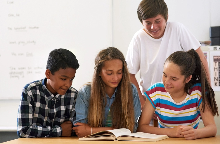 Students engaged in group reading activity at school, enhancing learning and teamwork skills in a classroom setting.
