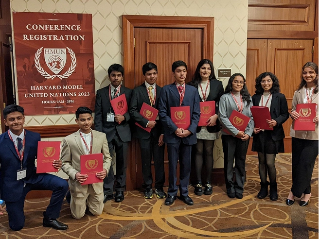 Group of students holding folders at Harvard Model United Nations 2023 conference registration.